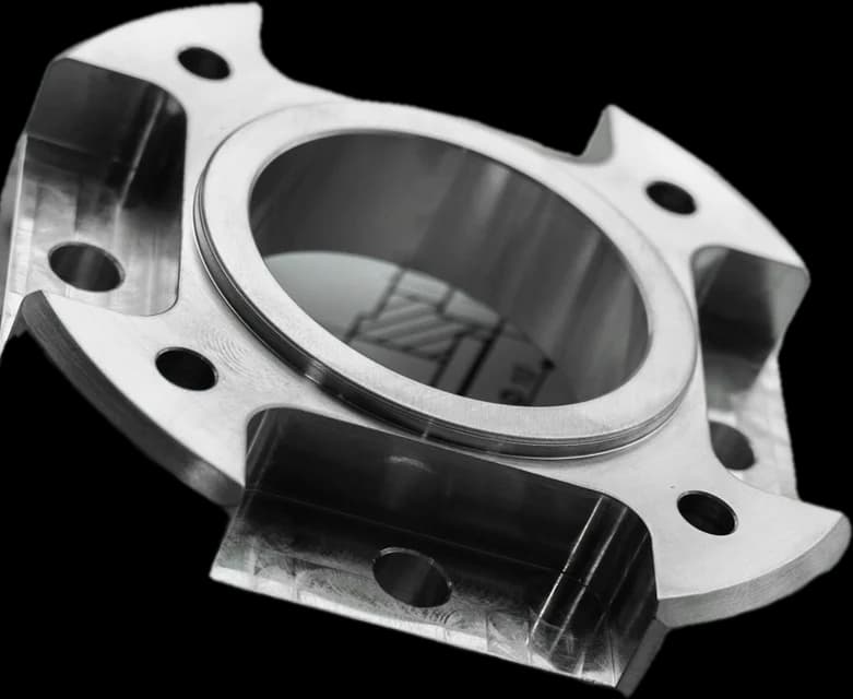 A CNC-machined steel flange with a precision bore and four bolt holes