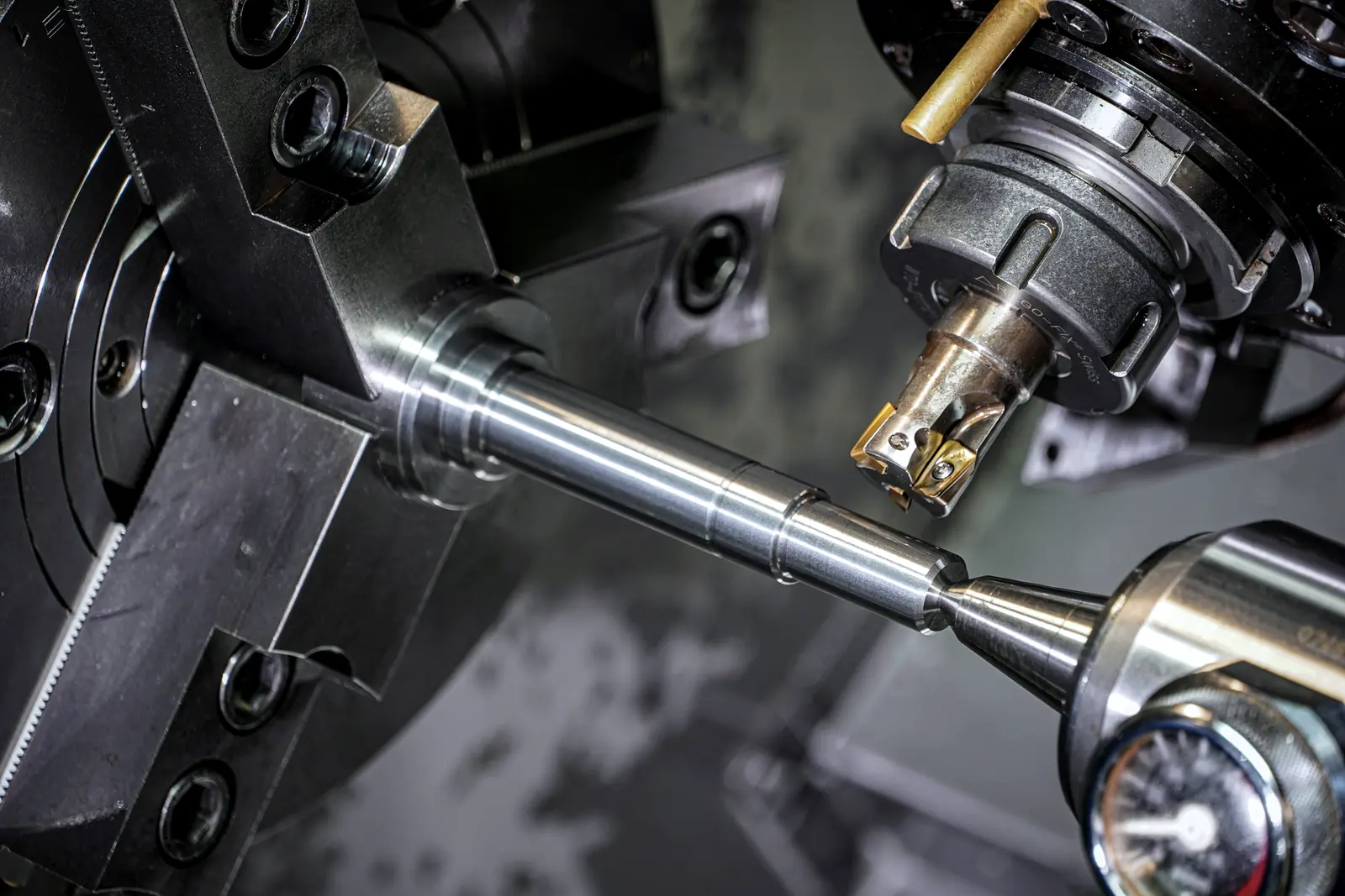 Finished steel shaft held in a lathe after its last cut